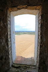 Obraz premium view from the small window of an ancient tower overlooking the plain and the desert