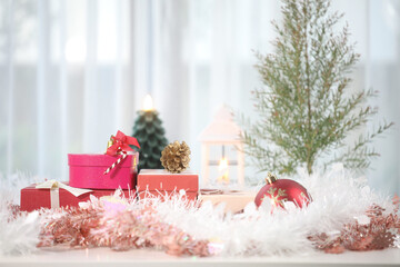 Christmas gift box with ornament and decoration on white table with small pine tree
