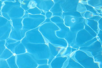 reflections of light on the blue water of the empty swimming pool ideal as a neutral background for vacation