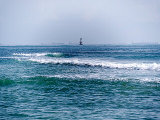 Novorossiysk, Russia 28 August 2024 Bulk carrier and lighthouse in the port in the Black Sea coast