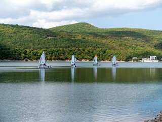 Abrau Durso, Russia 28 August 2024: Panoramic view of the lake Abrau-Durso with sailboats on a sunny day