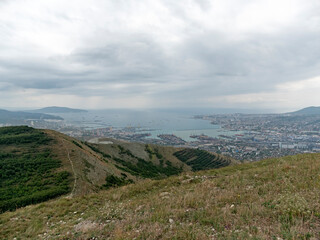Naklejka premium Panoramic view of Novorossiysk City and Tsemess Bay at sunrise. Morning cityscape of large port at Black Sea coast in Russia