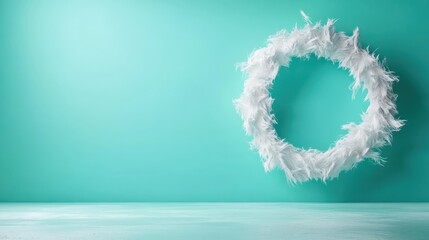 A decorative white feather wreath set against a turquoise background, capturing a minimalist and elegant appearance in contemporary home decor with simplicity.