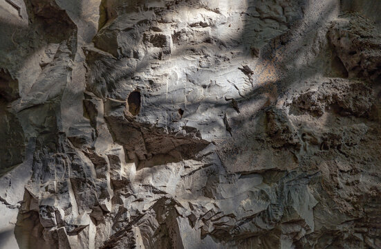 The sunlight shining through down to Limestone walls on the outside cave walls. Elegance of The intricate natural light and shadow on surface of stone wall, Pattern of granite on the mountains that er