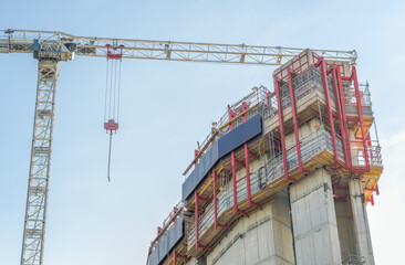 A construction site in Canary Wharf, London, with a large crane and a partially built concrete...