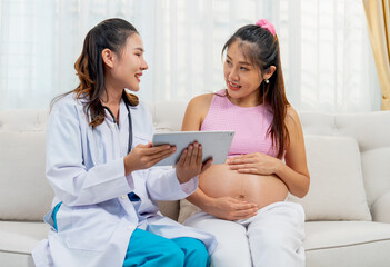Obraz premium Doctor or nurse sit together with Asian pregnancy woman and discuss abouth mother health at home with happiness.