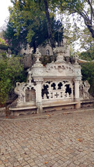 Marble Bench in the luxurious park with romantic and symbolic buildings. Quinta da Regaliera, a public interest property in Sintra, Lisbon, Portugal.  