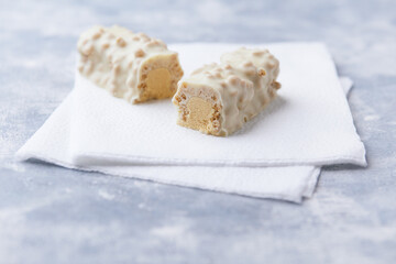 Protein bar in two pieces on wooden background. Soft focus. Close up. Copy space