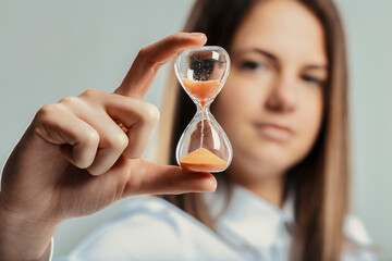 Businesswoman holding hourglass symbolizing time management