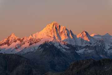 snowy peaks of rocky mountains in the red light of dawn