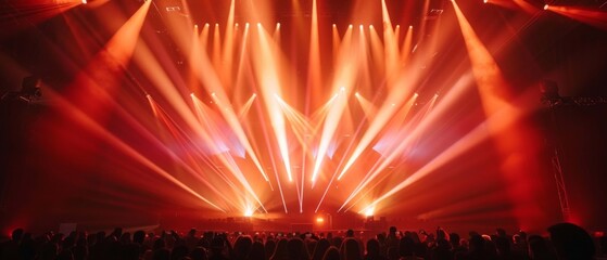 Vibrant lights illuminate concert stage, creating electrifying atmosphere. Silhouetted crowd...