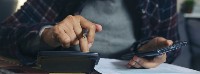 Budget and Tax planning concept. Acountant hand using calculator and review tax form. Represents personal finance, tax preparation, and budgeting, season to pay tax-banner image.