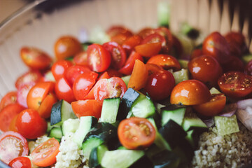 sliced juicy tomatoes cucumbers with grains in a salad glass bowl healthy living background