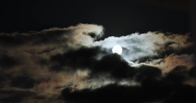 Full moon in Zimbabwe, Africa clear dark sky as timelapse, movement, and time changes quickly as the lunar bright source moves fast through clouds in a night and natural landscape