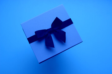 Blue Leather Gift Case With Decorative Bow Isolated on Blue Background. Holidays and Gifts Concept Design for Greeting Theme