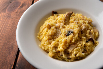 Delizioso risotto con zafferano e funghi, cibo vegetariano italiano 