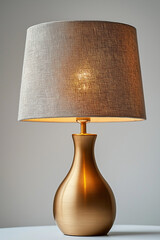 Photographie studio d'une lampe &agrave; poser moderne avec base en laiton &eacute;pur&eacute; et abat-jour en tissu, design minimaliste sur fond blanc