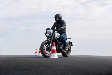 Motorcycle rider riding between traffic cones.