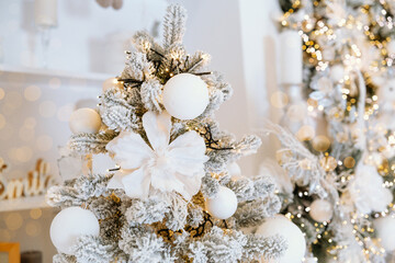 Decorative Christmas tree adorned with white ornaments and gleaming lights