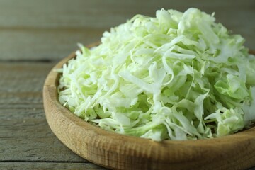 Fresh shredded cabbage on wooden table, closeup