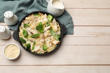 Delicious pasta Alfredo with chicken served on wooden table, flat lay. Space for text © New Africa