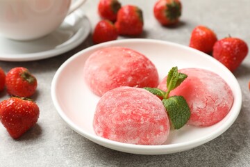 Delicious mochi, strawberries and mint on gray textured table, closeup