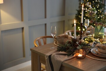 Christmas celebration. Festive table setting with dishware, glasses and decor in room