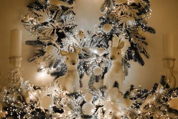 Festive decor featuring reindeer and winter lights near a Christmas tree