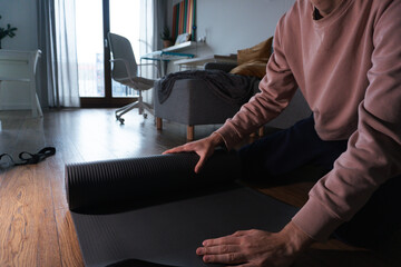Person Unrolling Yoga Mat at Home