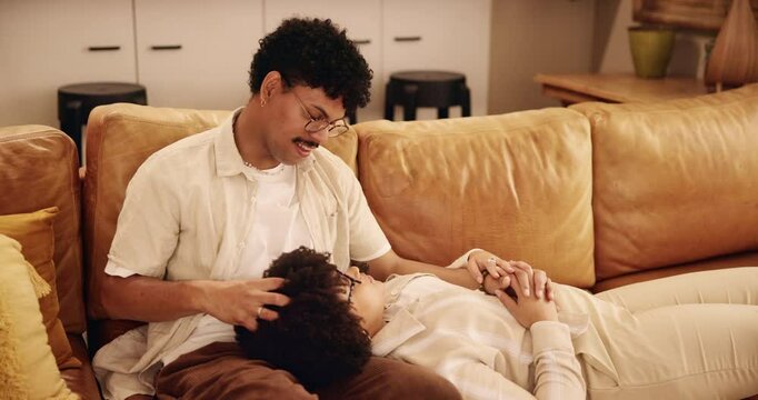 Smile, couple and relax on couch at house with love, calm weekend and discussion for bonding together. Happy, people and head massage, holding hands and communication for care of relationship romance