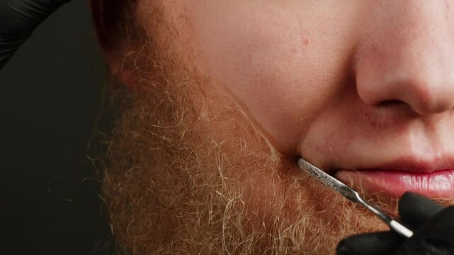 Make up artist making Disheveled blond beard for a man in theater with paint and glue, actors sfx cinema make up, close-up. Mens fashion, halloween style. making old guy.