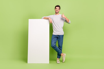 Full size photo of cheerful emotion casual wear man show thumb-up recommend you product isolated on green color background