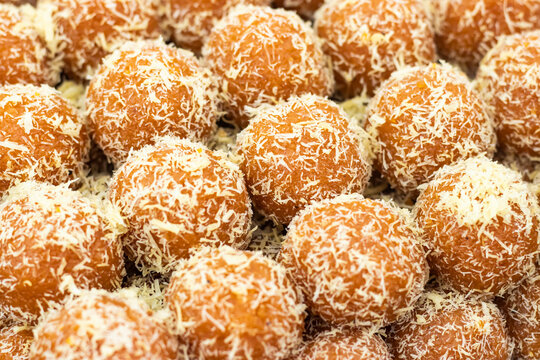 Lal Semai Laddu topped with coconut coating texture closeup side view of Indian, pakistani and bangladeshi sweet dessert food