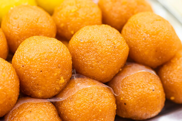 Orange Laddu texture closeup side view of Indian, pakistani and bangladeshi sweet dessert food