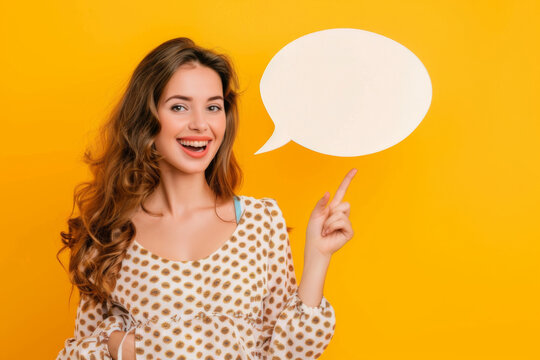 Cheerful woman in a hat holding a blank speech bubble against a vibrant yellow background, ready for your text.