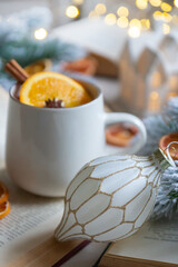 New Year 2025, tea with orange, coffee with marshmallows, books and fir branches, New Year's toys and a ball on the table.