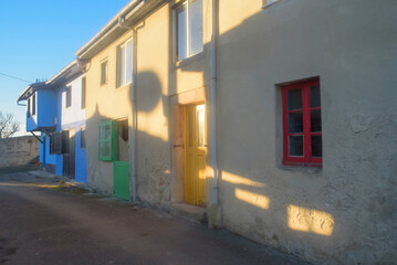 Puertas y ventanas de colores en calle de pueblo al atardecer o amanecer