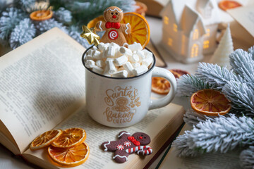 New Year 2025, tea with orange, coffee with marshmallows, books and fir branches, New Year's toys and a ball on the table.