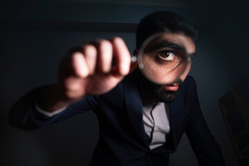 man hand holding magnifier in eye