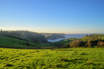 Fototapeta premium Bahía y horizonte marino tras praderas verdes en litoral de Asturias
