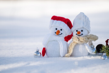 Two toy snowman knitted in the snow , copy space banner