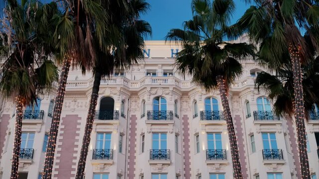View of palm trees in front of the Carlton Hotel on the coast of the city, Cannes, France