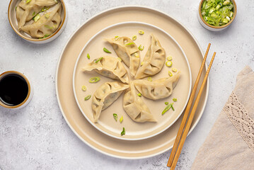 Food photography of vegetable gyoza dumplings, jiaozi, spring onion, soy sauce, steamed and stuffed dumplings, chopsticks, portion, vegetarian food, Chinese cuisine, Asian meal