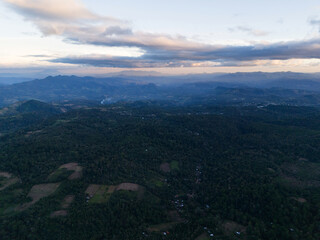 Aerial view of mountains and forested landscape during twilight hours in rural area