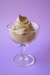 Close-up mocha mousse pudding in a glass on purple background 