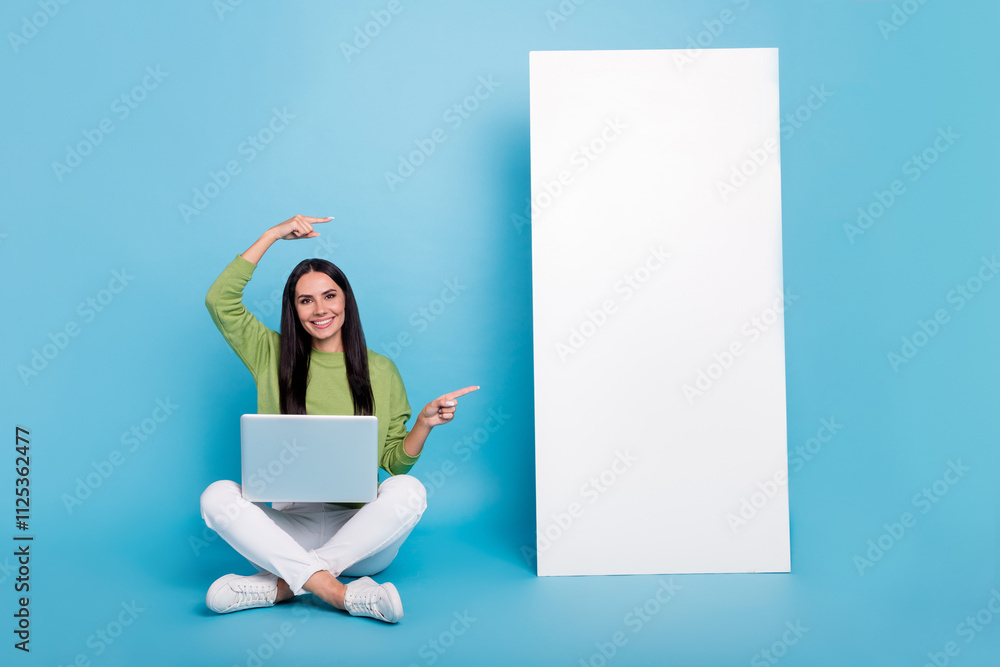 Poster full size portrait of cheerful pretty person sit floor direct fingers empty space isolated on blue c