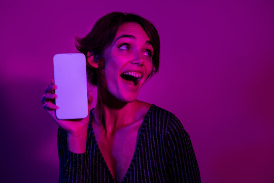 Photo portrait of pretty young girl white screen look empty space wear trendy overall outfit isolated on neon light pink color background