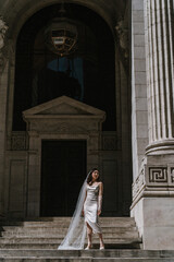 Elegant Bride Gracefully Posing in Beautiful Architectural Setting with a Veil