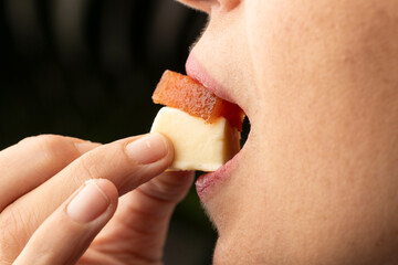 The image captures a close-up view of a person holding a skewer with a piece of food, emphasizing the moment before taking a bite, showcasing texture and colors.