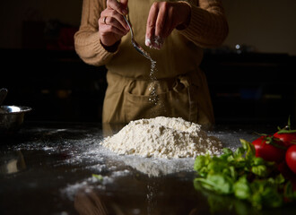 Chef preparing dough with fresh ingredients in a cozy kitchen setting